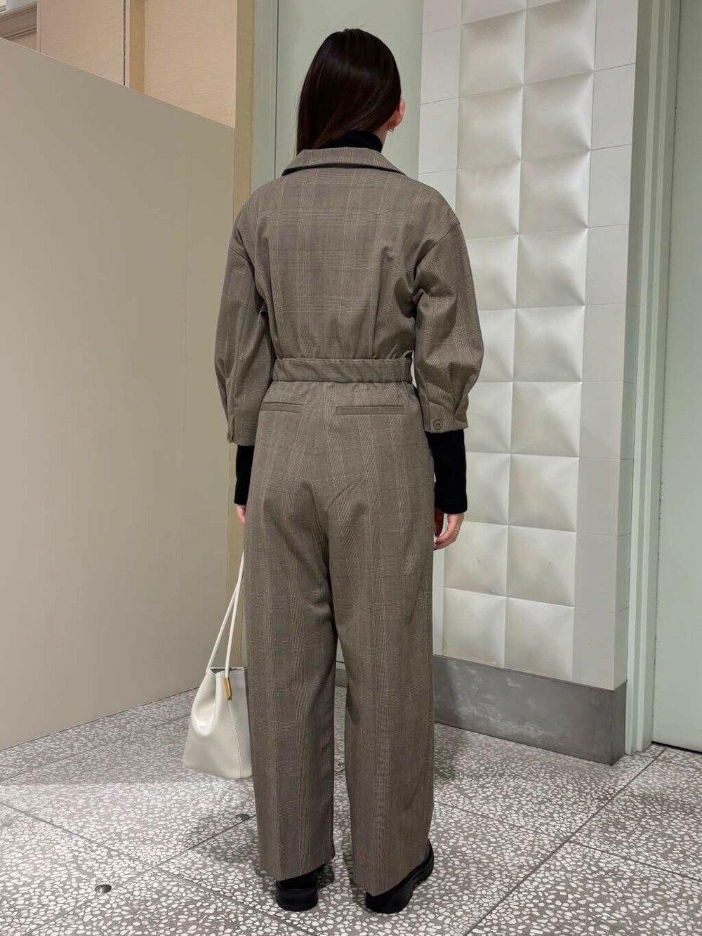 ブラック系のTシャツ/カットソー、ブラック系のブーツ、ホワイト系のトートバッグを着用したレディースの秋コーディネートの3枚目の写真