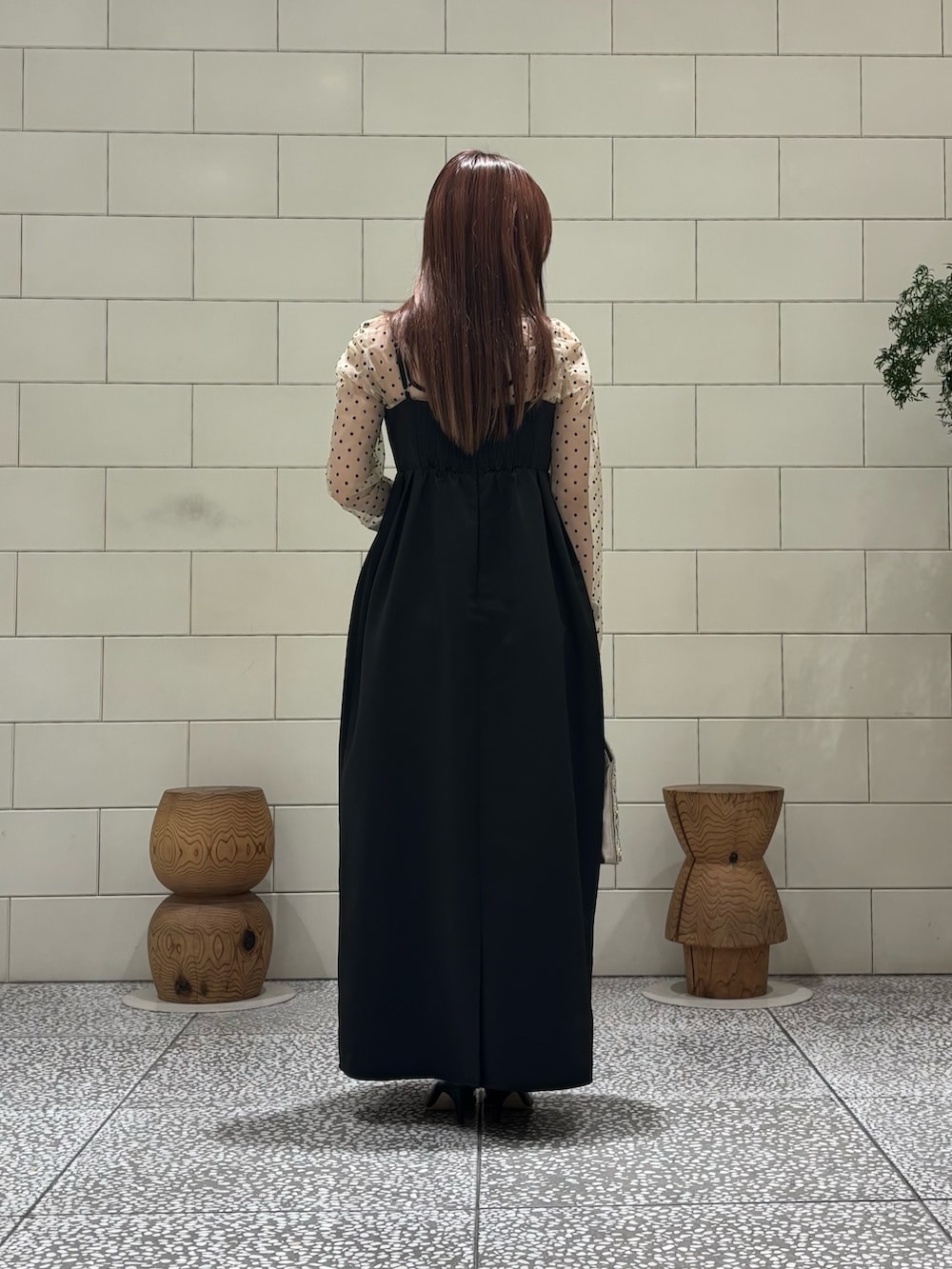 ブラック系のパンプス、ベージュ系のハンドバッグを着用したレディースの春コーディネートの2枚目の写真