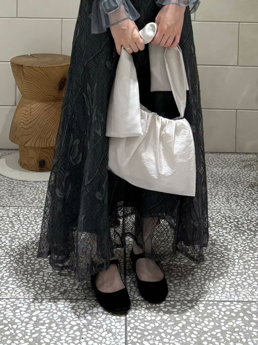 グレー系のワンピース、ベージュ系のハンドバッグ、ブラック系のパンプスを着用したレディースの秋コーディネートの5枚目の写真