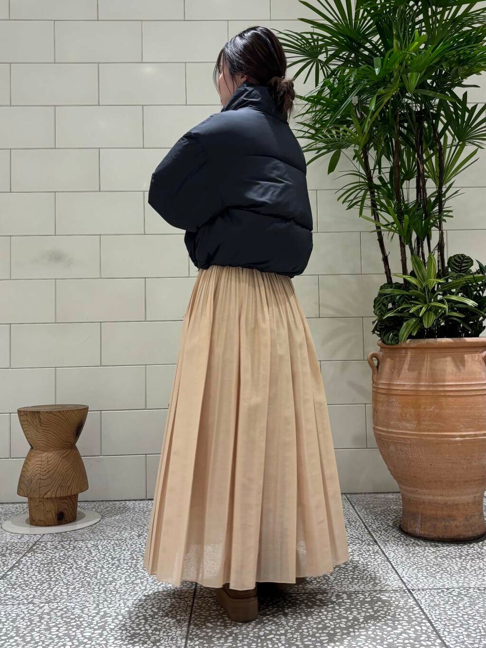 イエロー系のスカート、ブラウン系のカーディガン/ボレロ、ブラウン系のブーツを着用したレディースの冬コーディネートの3枚目の写真