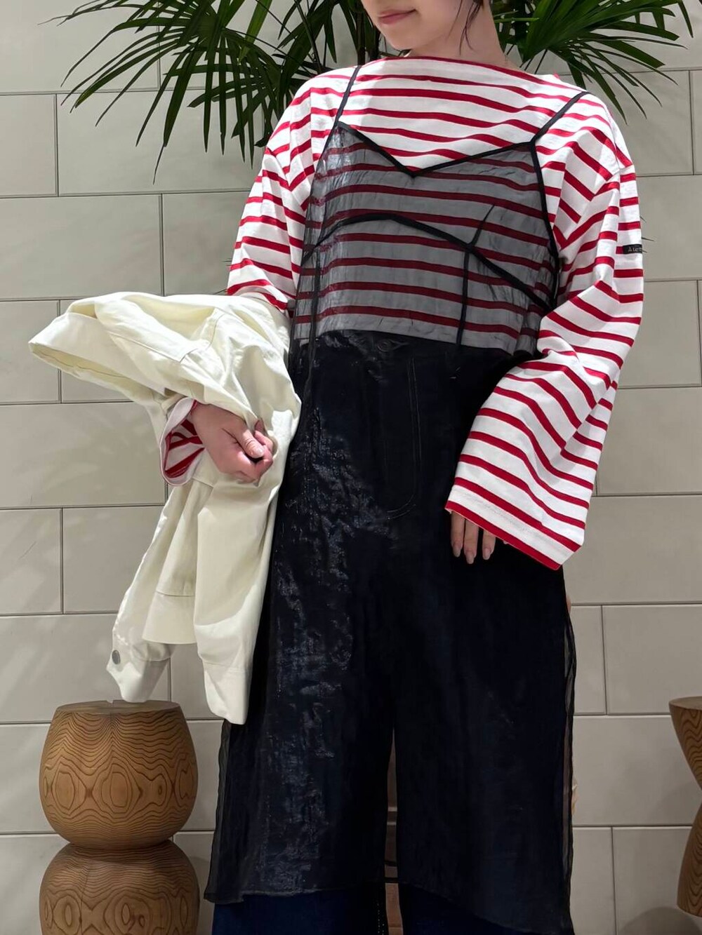 ホワイト系のスニーカー、ブラック系のワンピース、ブルー系のデニムパンツを着用したレディースの冬コーディネートの7枚目の写真