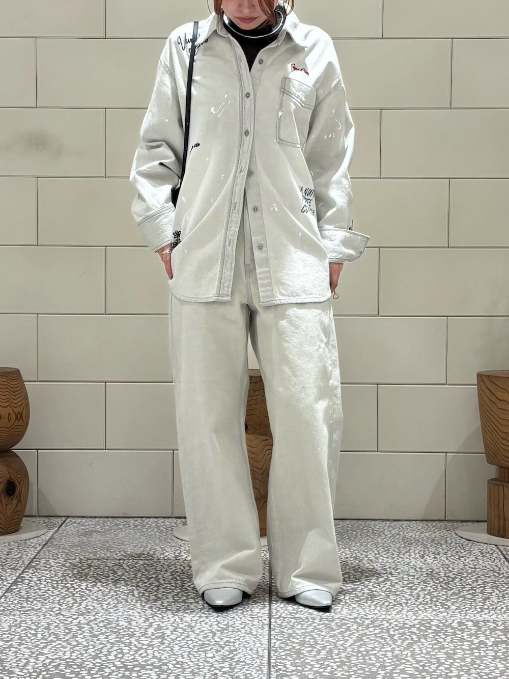 ブラック系のTシャツ/カットソー、グレー系のシャツ/ブラウス、グレー系のデニムパンツを着用したレディースの冬コーディネートの2枚目の写真