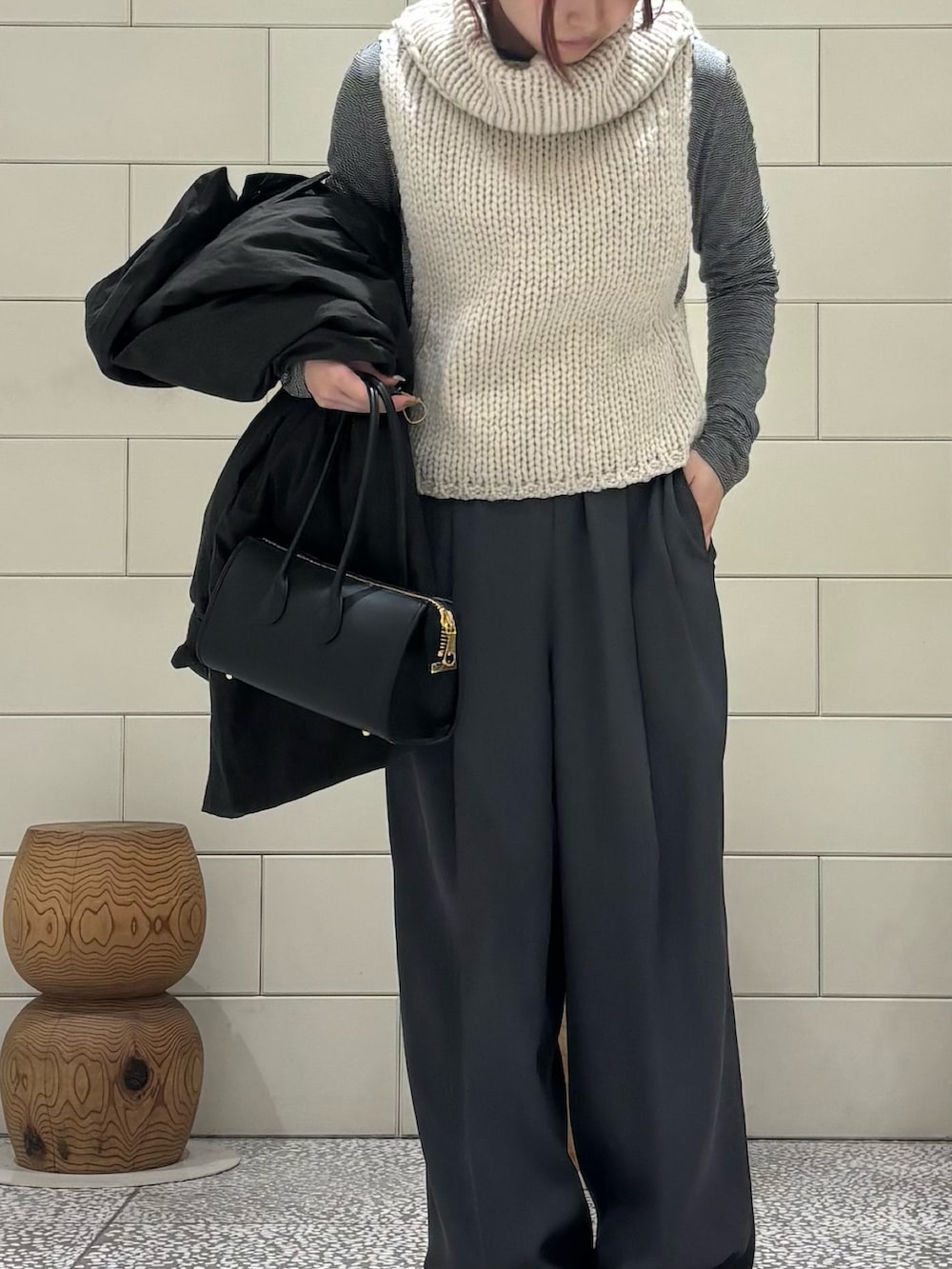 ブラック系のTシャツ/カットソー、ホワイト系のベスト、グレー系のその他パンツを着用したレディースの冬コーディネートの6枚目の写真