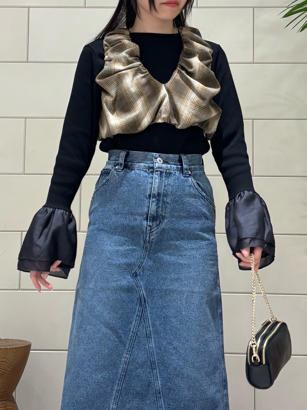 ブラック系のTシャツ/カットソー、ブルー系のスカート、ブラック系のショルダーバッグを着用したレディースの冬コーディネートの3枚目の写真