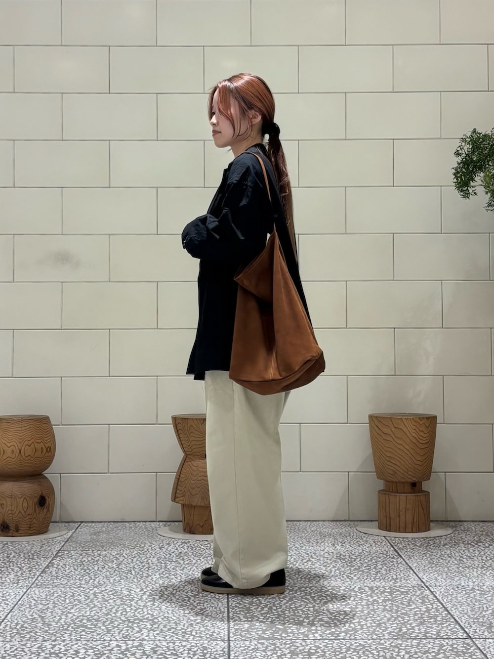 グレー系のニット/セーター、ブラウン系のトートバッグ、ブラック系のその他アウターを着用したレディースの冬コーディネートの3枚目の写真