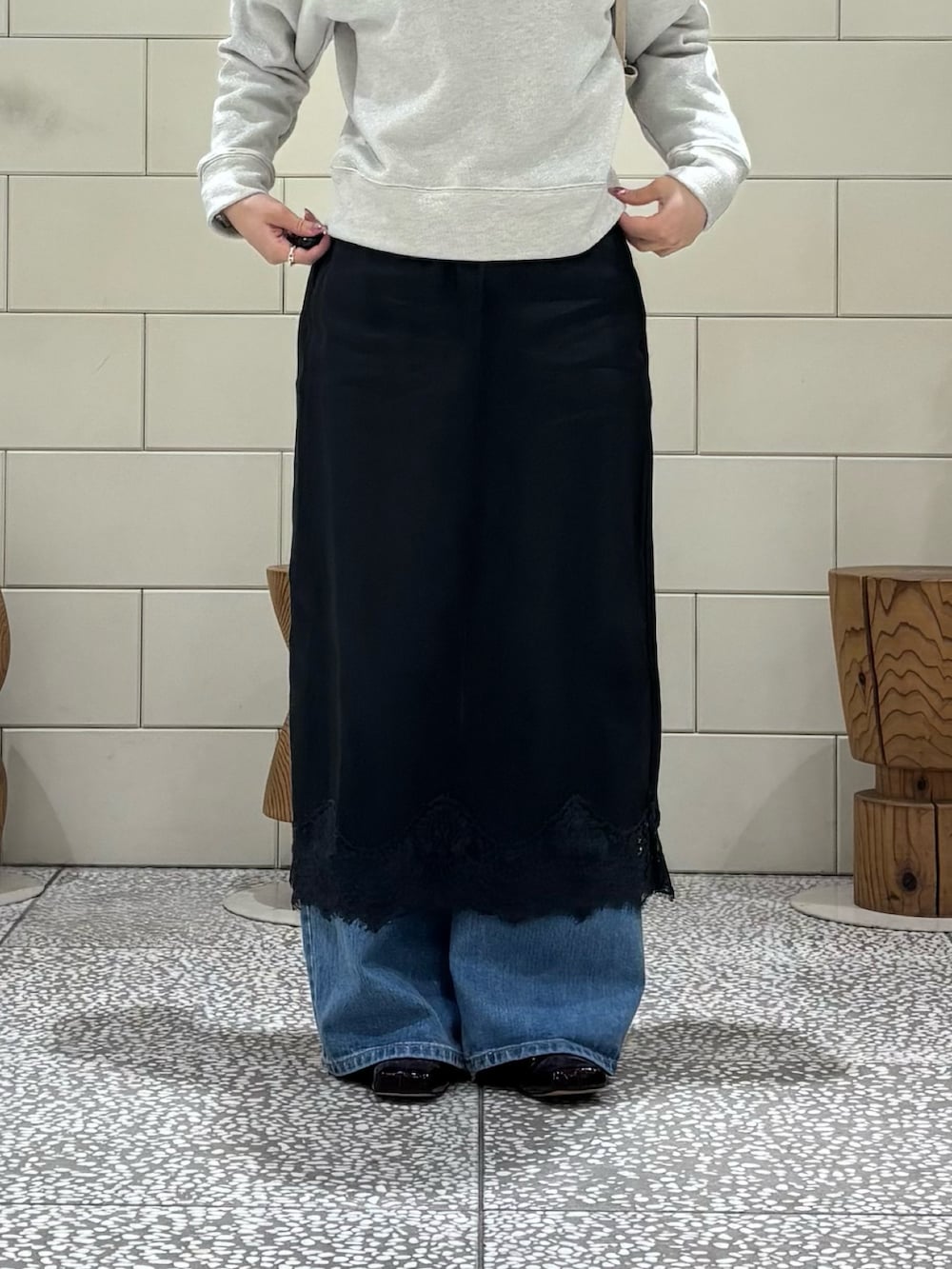 ホワイト系のスウェット、ホワイト系のスカート、ブルー系のデニムパンツを着用したレディースの冬コーディネートの5枚目の写真