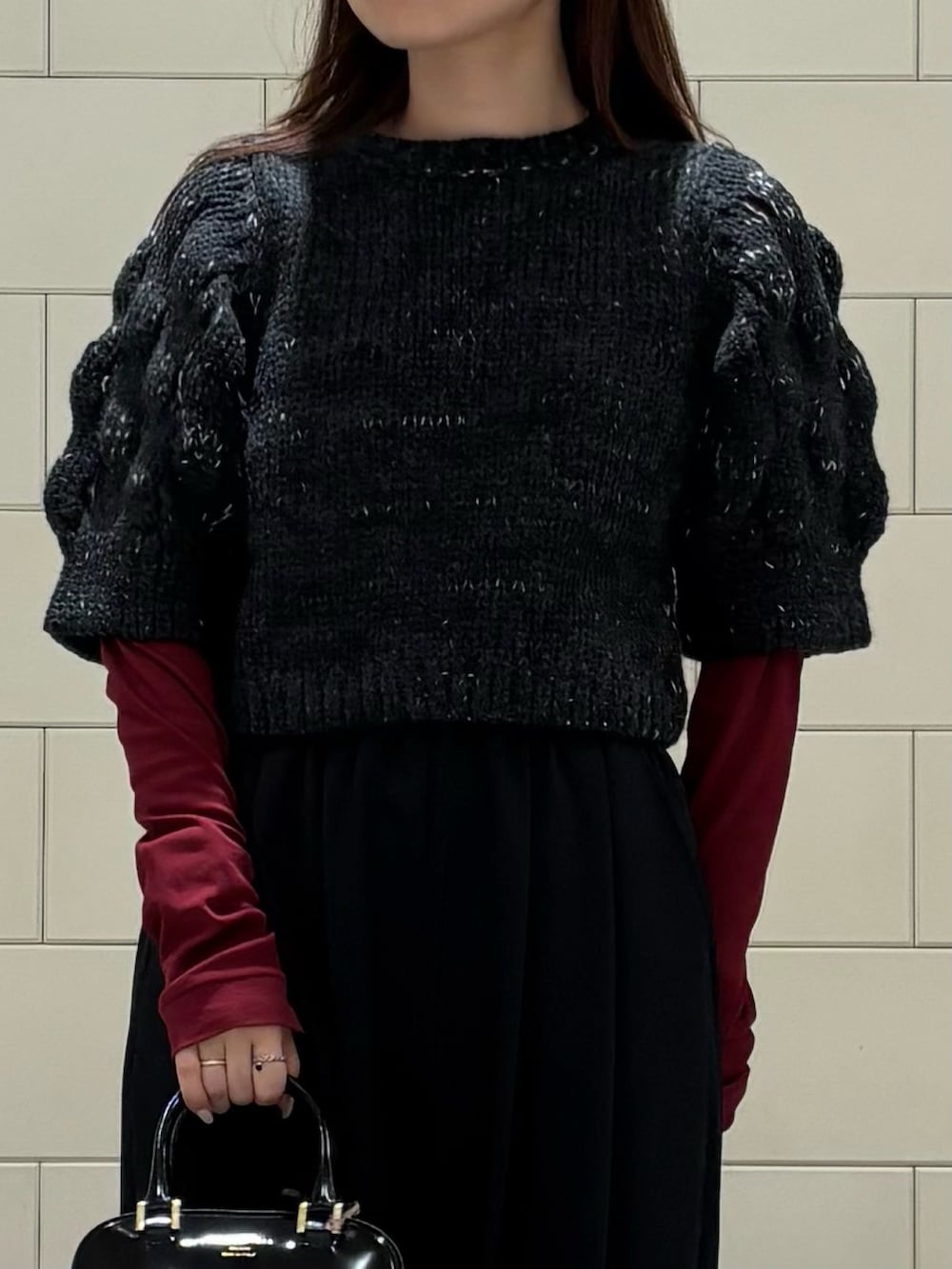 レッド系のTシャツ/カットソー、ブラック系のその他パンツ、ブラック系のニット/セーターを着用したレディースの秋コーディネートの2枚目の写真