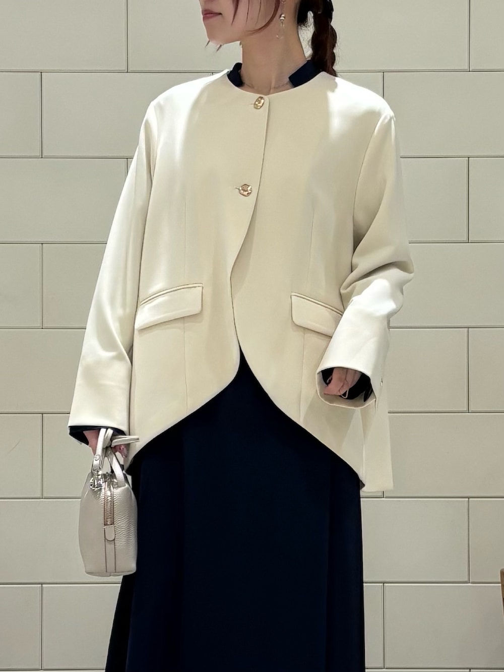 ブルー系のワンピース、ホワイト系のスーツジャケット、ホワイト系のショルダーバッグを着用したレディースの冬コーディネートの5枚目の写真