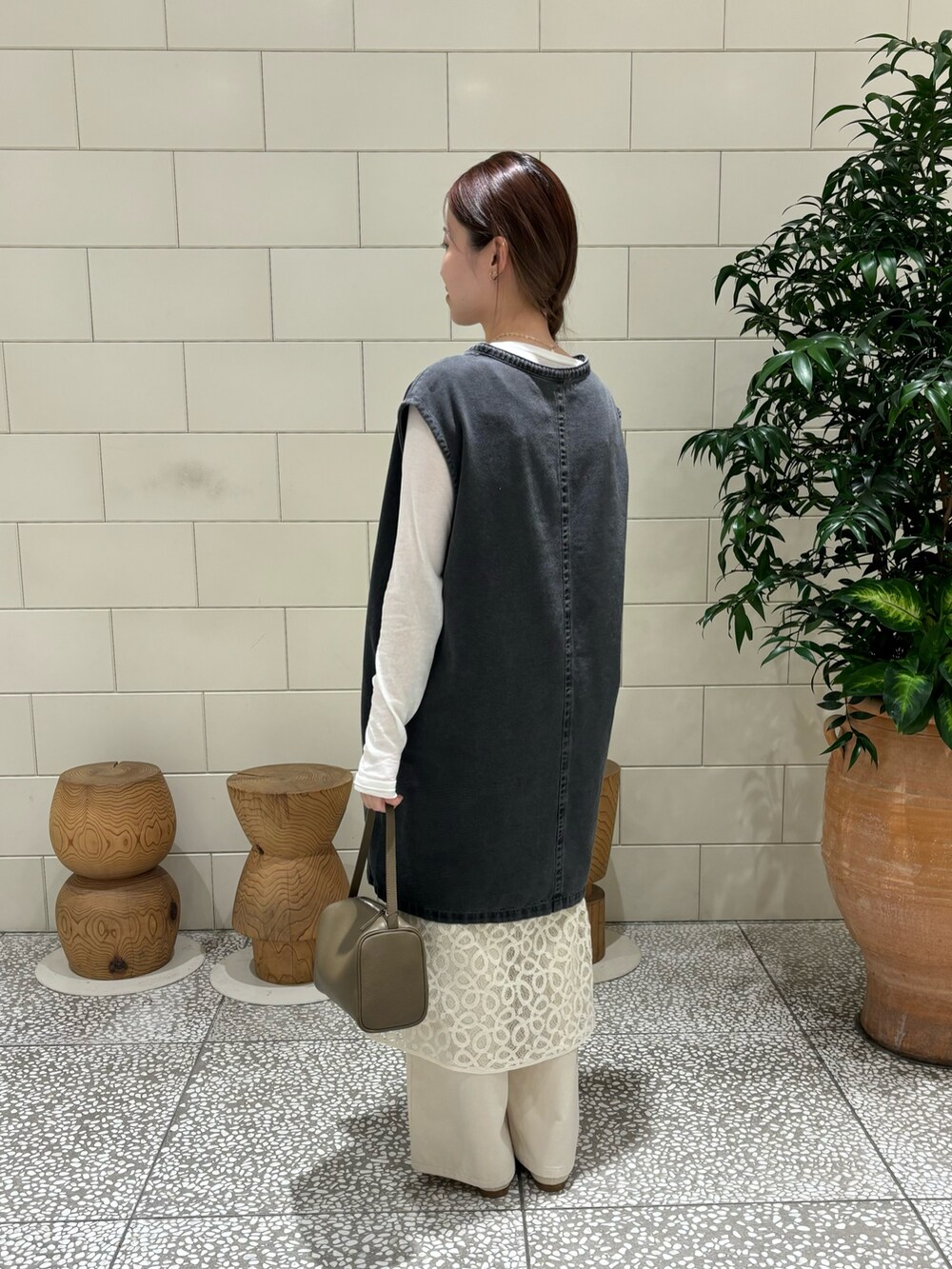 ホワイト系のTシャツ/カットソー、ブラック系のベスト、ベージュ系のハンドバッグを着用したレディースの夏コーディネートの3枚目の写真