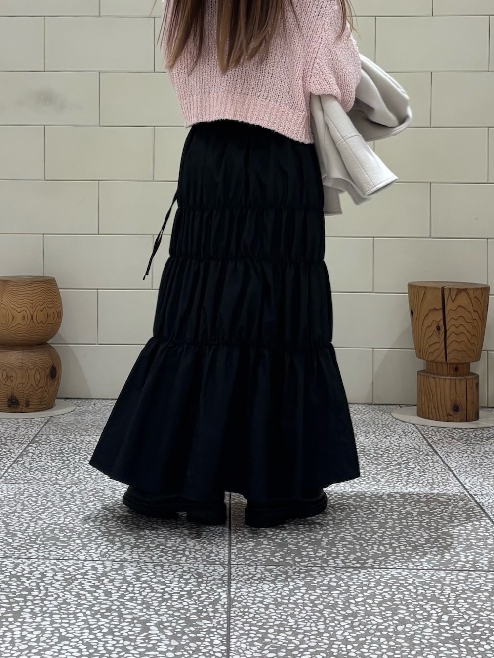 ピンク系のニット/セーター、ブラック系のスカート、ホワイト系のその他アウターを着用したレディースの冬コーディネートの5枚目の写真