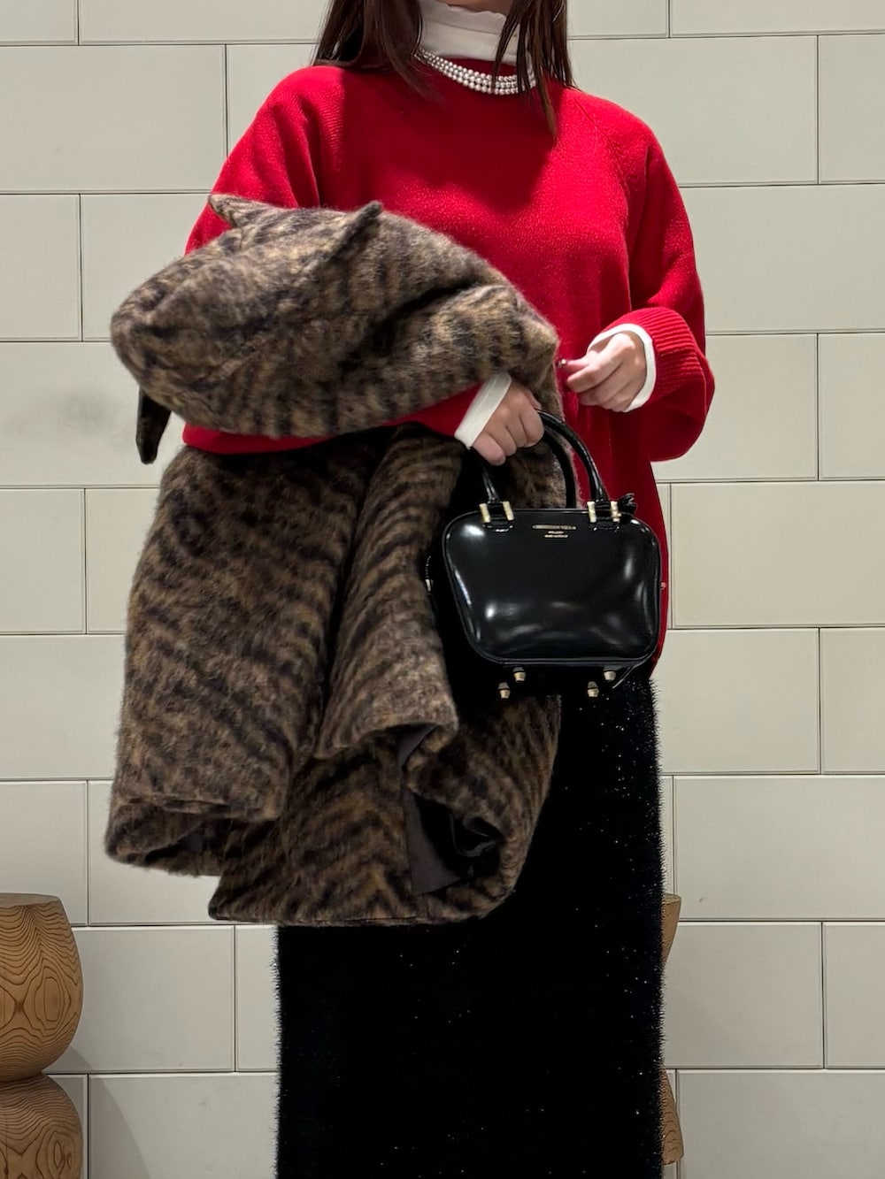 ホワイト系のTシャツ/カットソー、レッド系のニット/セーター、ベージュ系のピーコートを着用したレディースの秋コーディネートの5枚目の写真