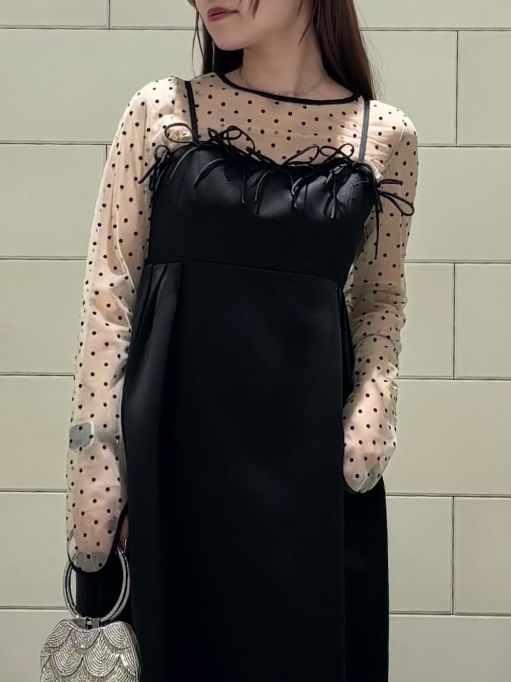 ブラック系のパンプス、ベージュ系のハンドバッグを着用したレディースの春コーディネートの4枚目の写真