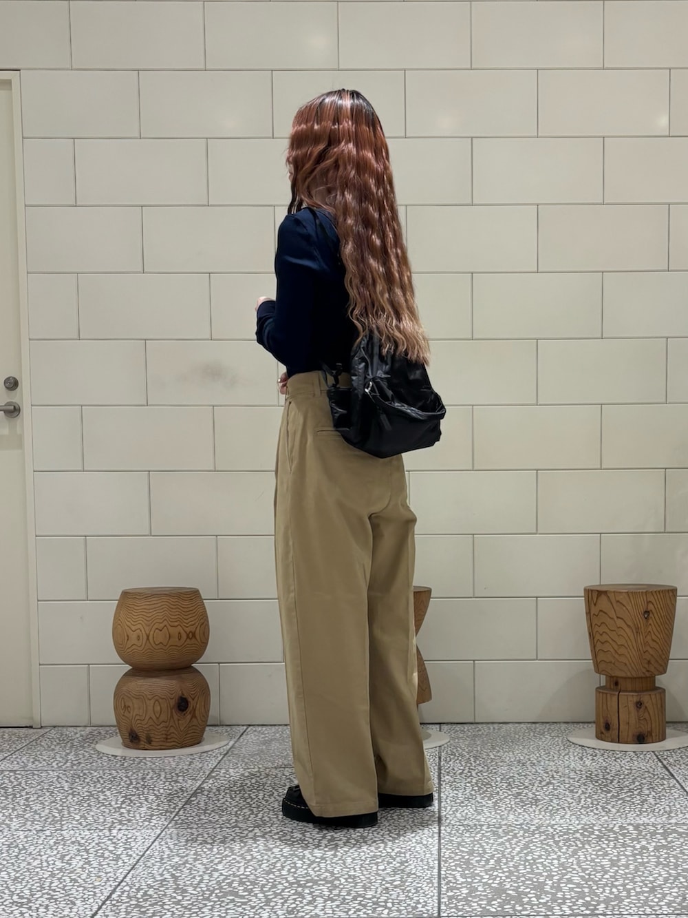 ベージュ系のその他パンツ、ベージュ系のカバーオール、ブラウン系のバックパック/リュックを着用したレディースの冬コーディネートの2枚目の写真