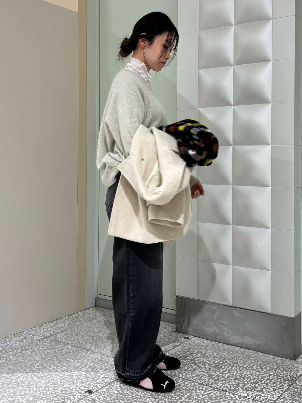 ベージュ系のピーコート、ホワイト系のTシャツ/カットソー、ブラック系のデニムパンツを着用したレディースの冬コーディネートの4枚目の写真