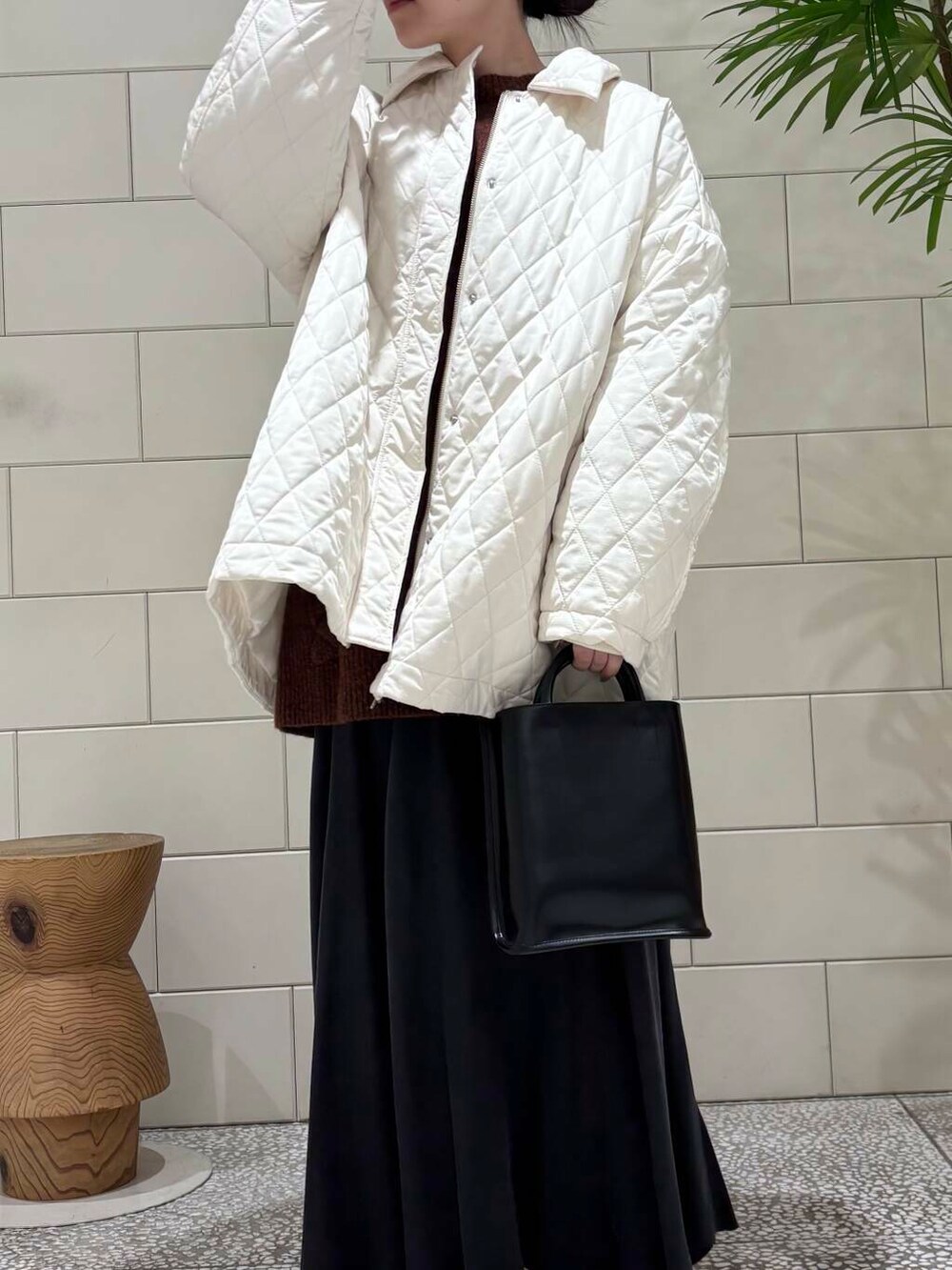 ホワイト系のスニーカー、ブラック系のトートバッグ、ブラウン系のニット/セーターを着用したレディースの冬コーディネートの5枚目の写真