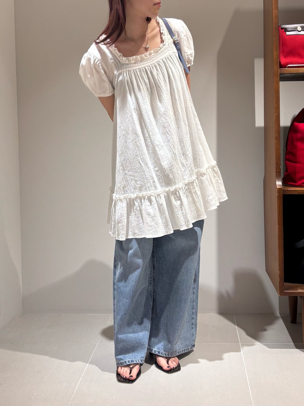 ホワイト系のシャツ/ブラウス、ブルー系のデニムパンツ、ブラック系のサンダルを着用したレディースの夏コーディネートの2枚目の写真