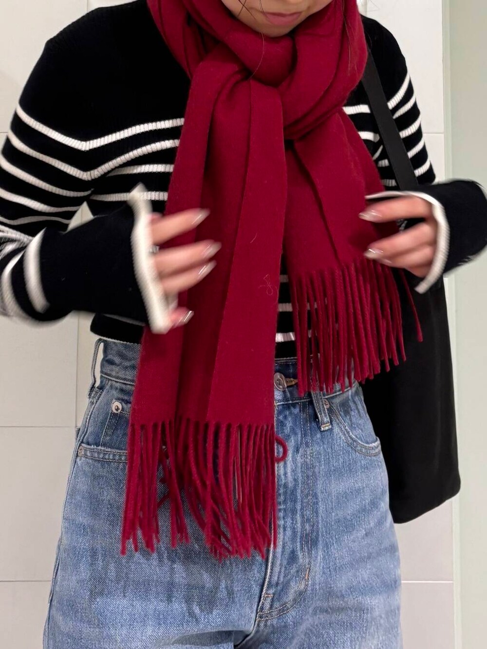 ブラック系のニット/セーター、ブルー系のデニムパンツ、ホワイト系のその他アウターを着用したレディースの秋コーディネートの6枚目の写真