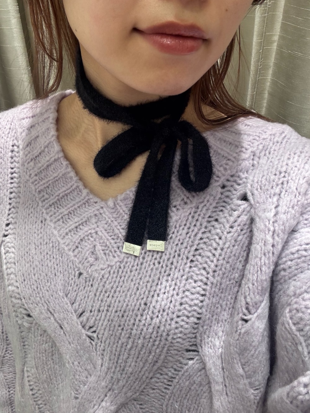 パープル系のニット/セーター、ホワイト系のピーコート、ブラック系のスカートを着用したレディースの冬コーディネートの5枚目の写真