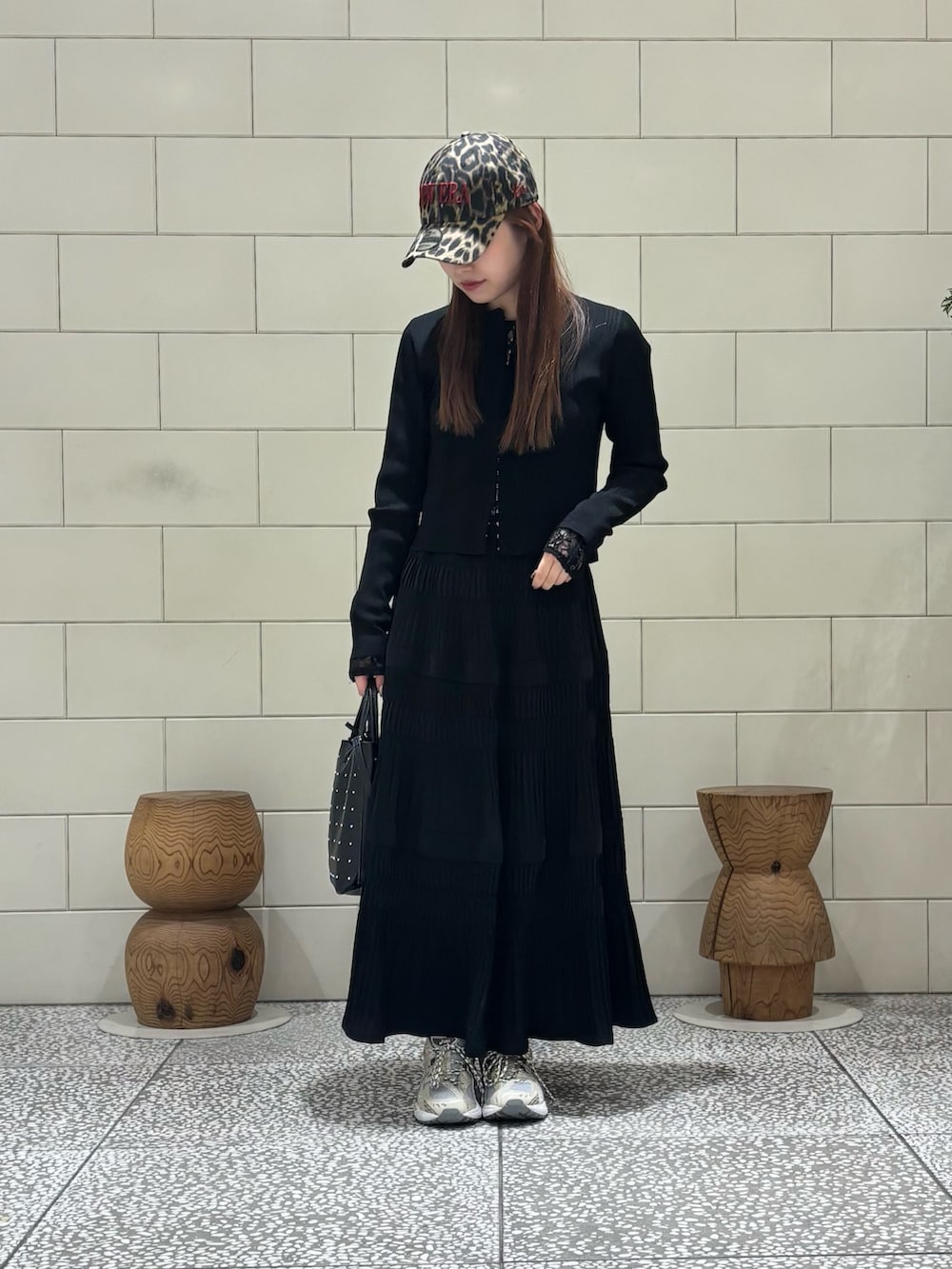 ブラック系のトートバッグ、ホワイト系のTシャツ/カットソー、ホワイト系のスニーカーを着用したレディースの春コーディネートの2枚目の写真