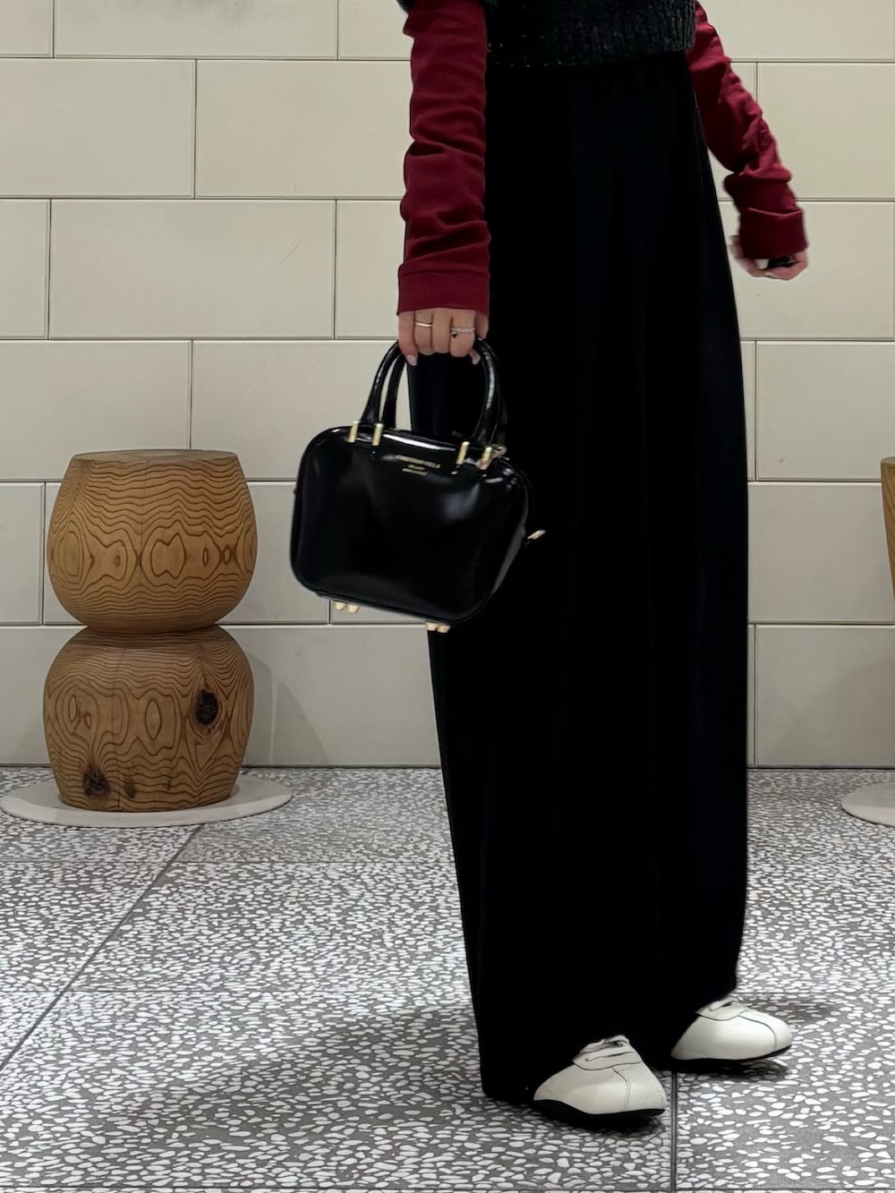 レッド系のTシャツ/カットソー、ブラック系のその他パンツ、ブラック系のニット/セーターを着用したレディースの秋コーディネートの4枚目の写真