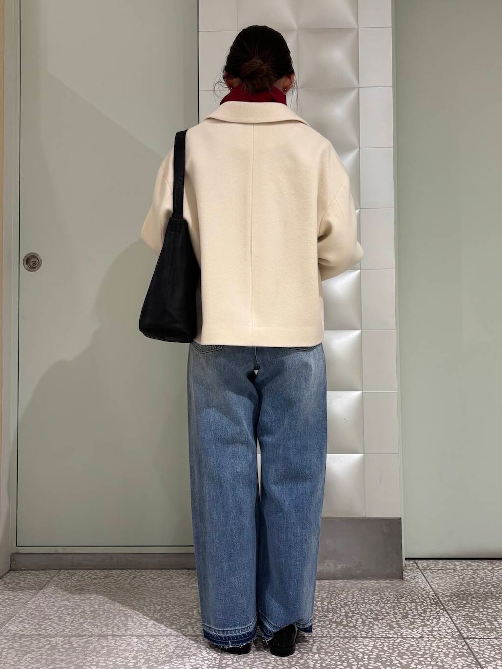 ブラック系のニット/セーター、ブルー系のデニムパンツ、ホワイト系のその他アウターを着用したレディースの秋コーディネートの3枚目の写真