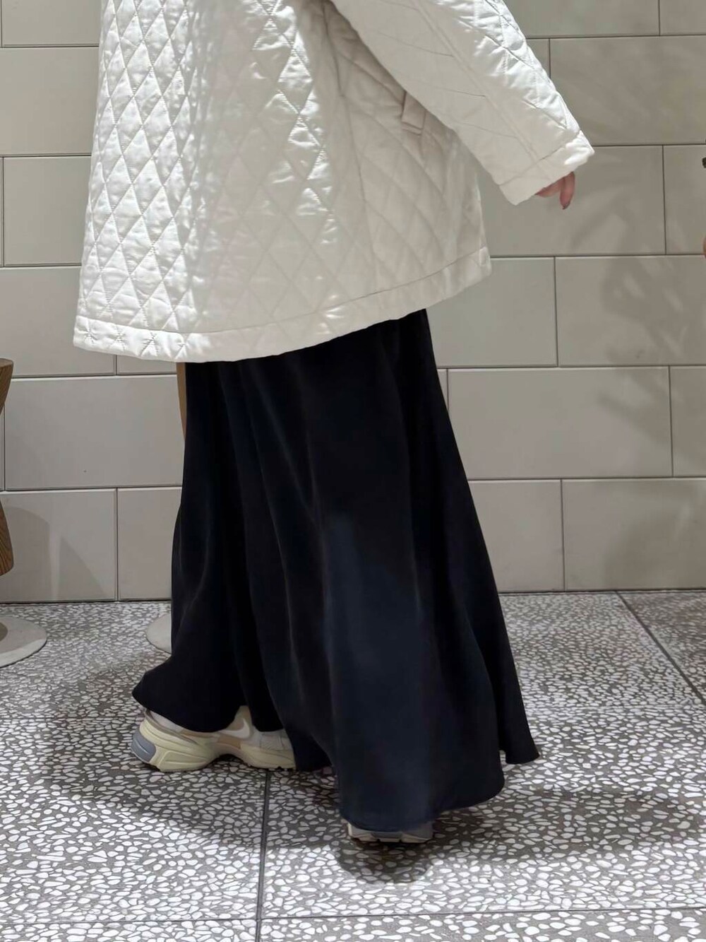 ホワイト系のスニーカー、ブラック系のトートバッグ、ブラウン系のニット/セーターを着用したレディースの冬コーディネートの6枚目の写真