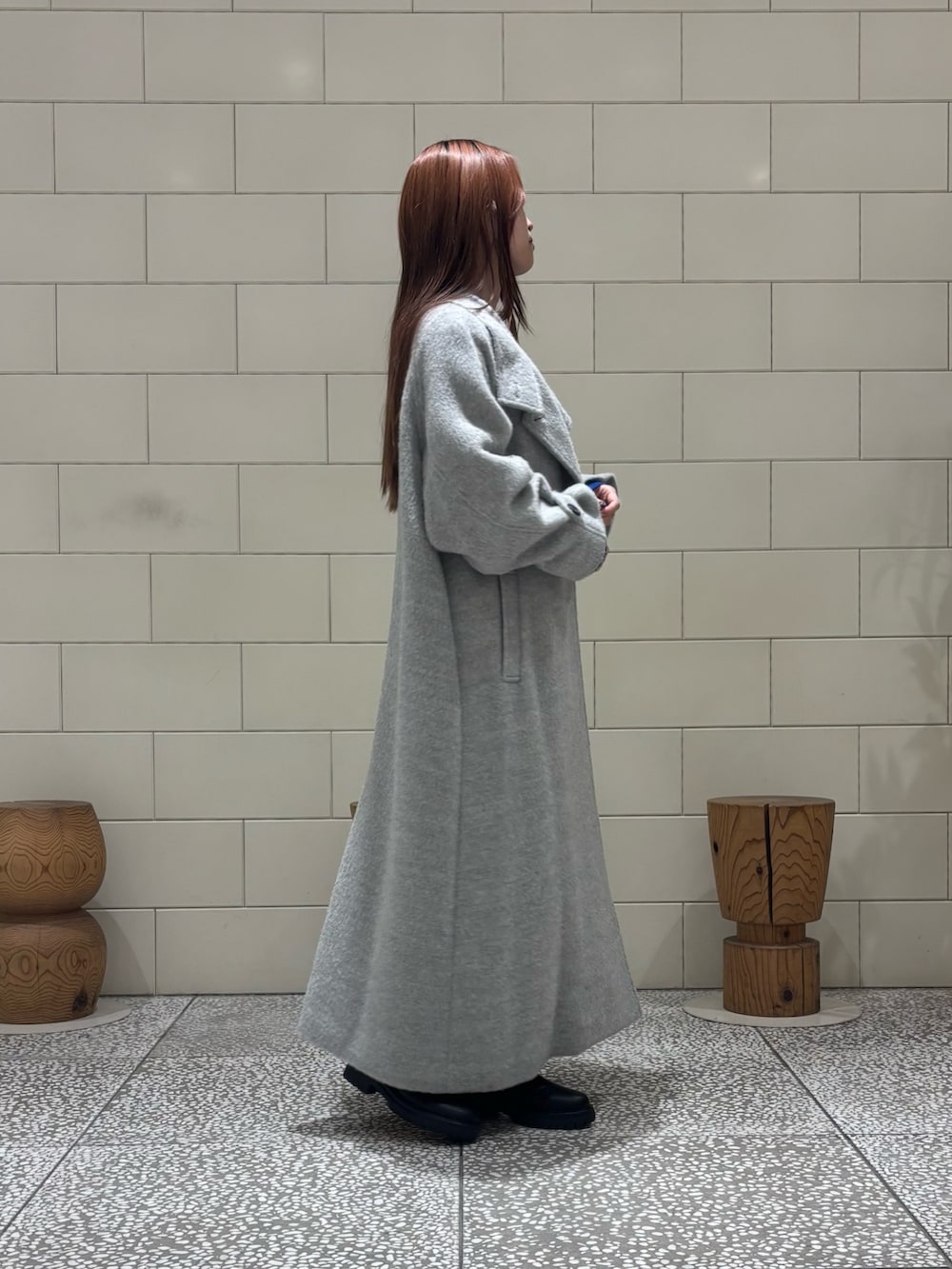 ブラック系のショルダーバッグ、ブラック系のブーツ、グレー系のその他アウターを着用したレディースの冬コーディネートの3枚目の写真