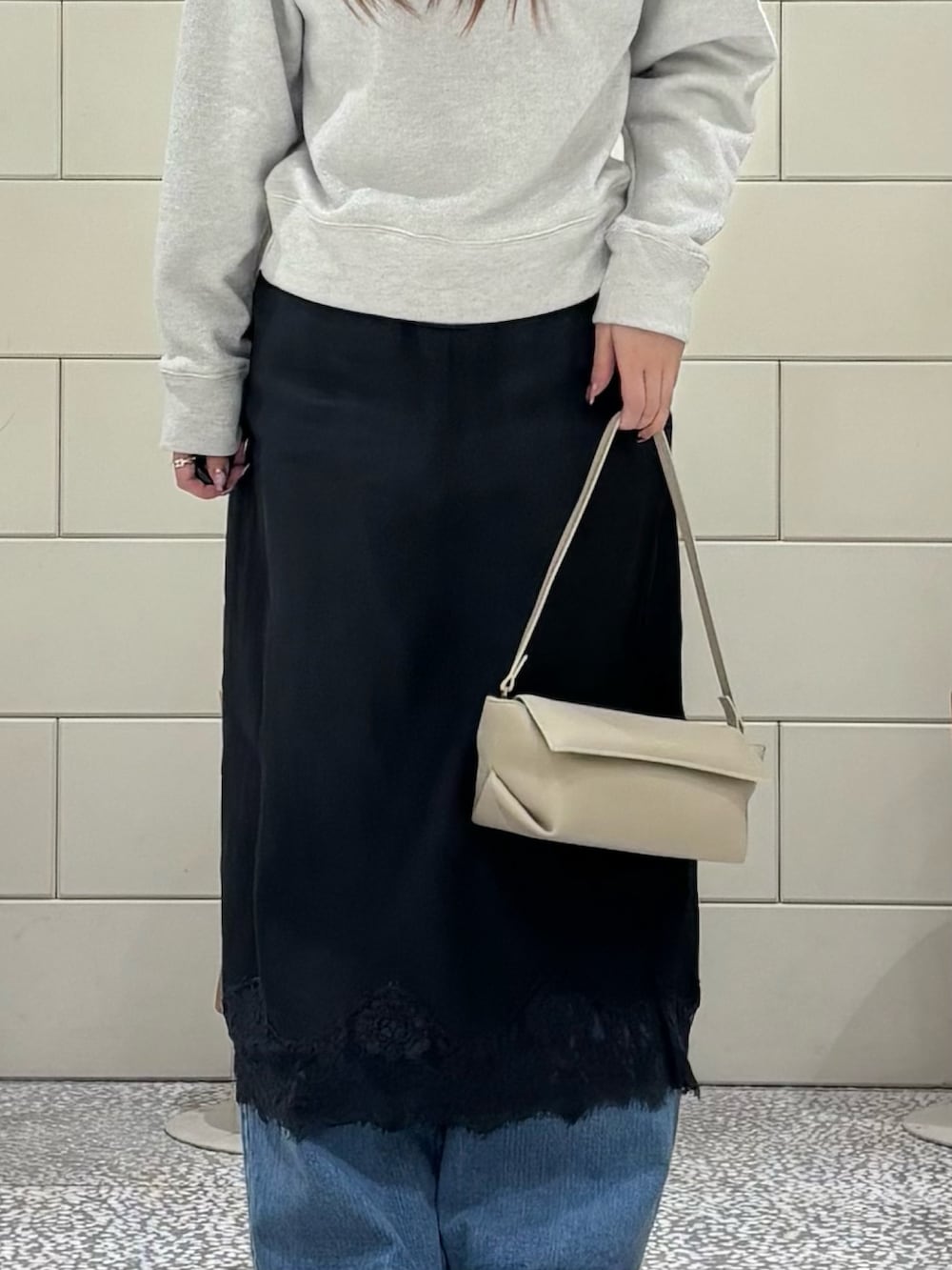 ホワイト系のスウェット、ホワイト系のスカート、ブルー系のデニムパンツを着用したレディースの冬コーディネートの4枚目の写真