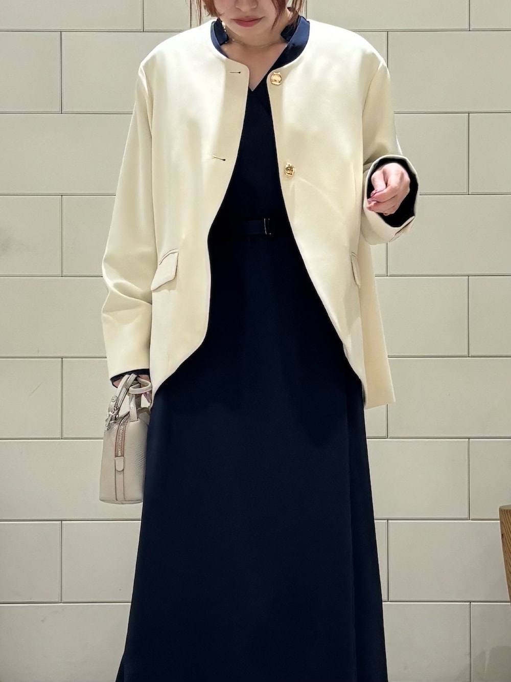 ブルー系のワンピース、ホワイト系のスーツジャケット、ホワイト系のショルダーバッグを着用したレディースの冬コーディネートの4枚目の写真