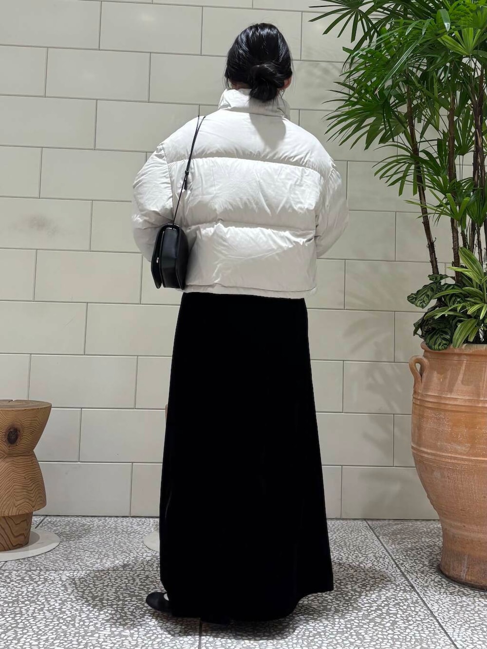 ブラック系のスカート、ベージュ系のカーディガン/ボレロ、ホワイト系のダウンジャケット/コートを着用したレディースの冬コーディネートの4枚目の写真