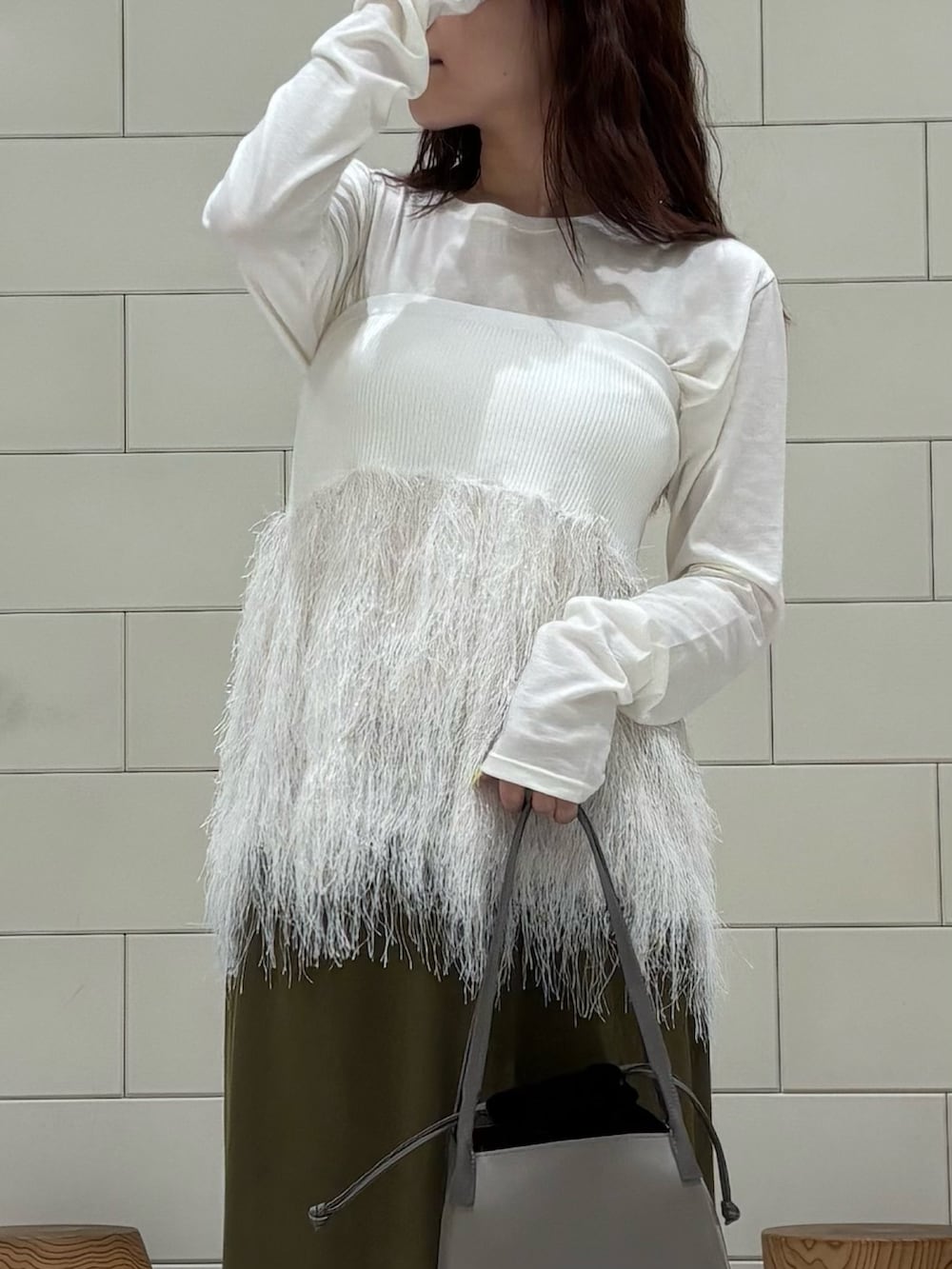 ホワイト系のTシャツ/カットソー、ホワイト系のニット/セーター、グリーン系のスカートを着用したレディースの秋コーディネートの2枚目の写真