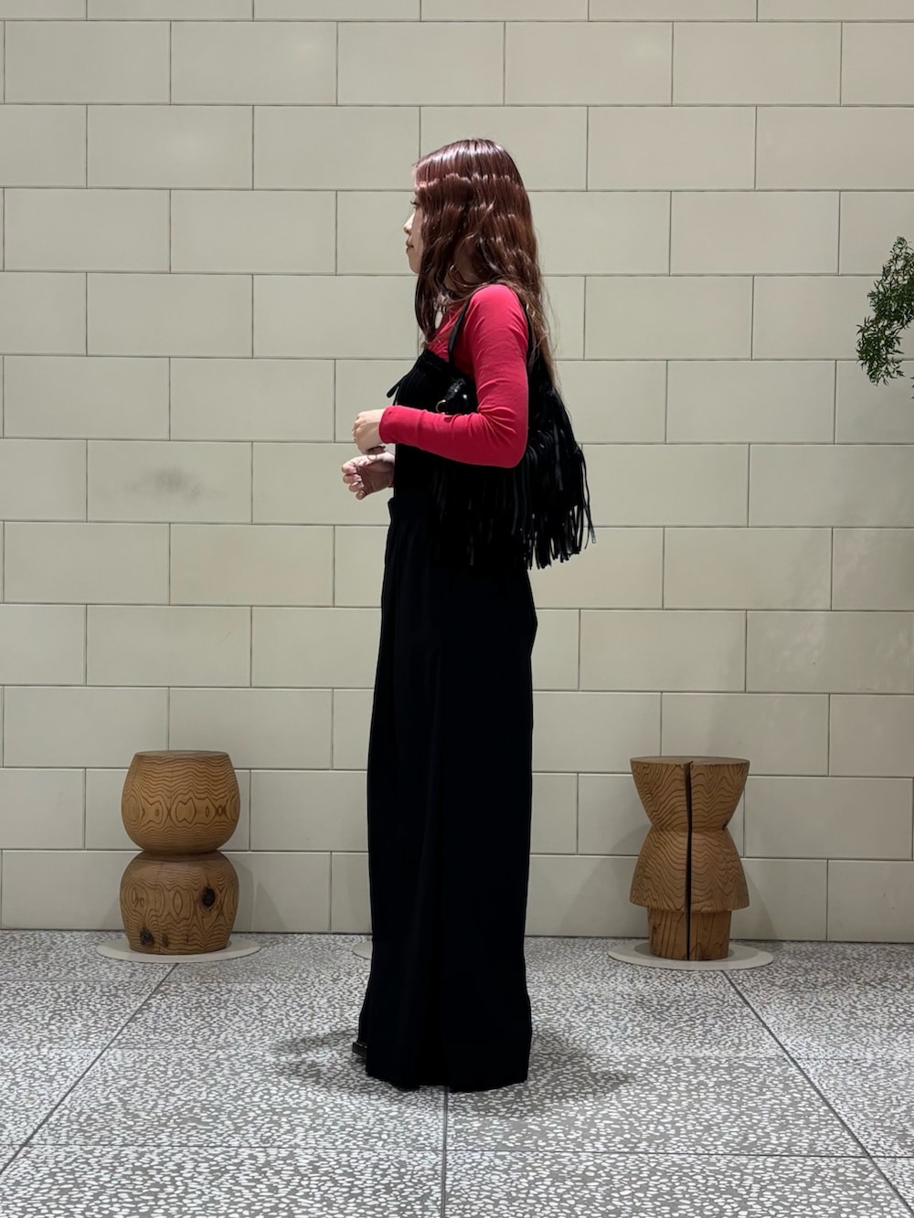 ブルー系のその他パンツ、ブラック系のハンドバッグを着用したレディースの春コーディネートの3枚目の写真