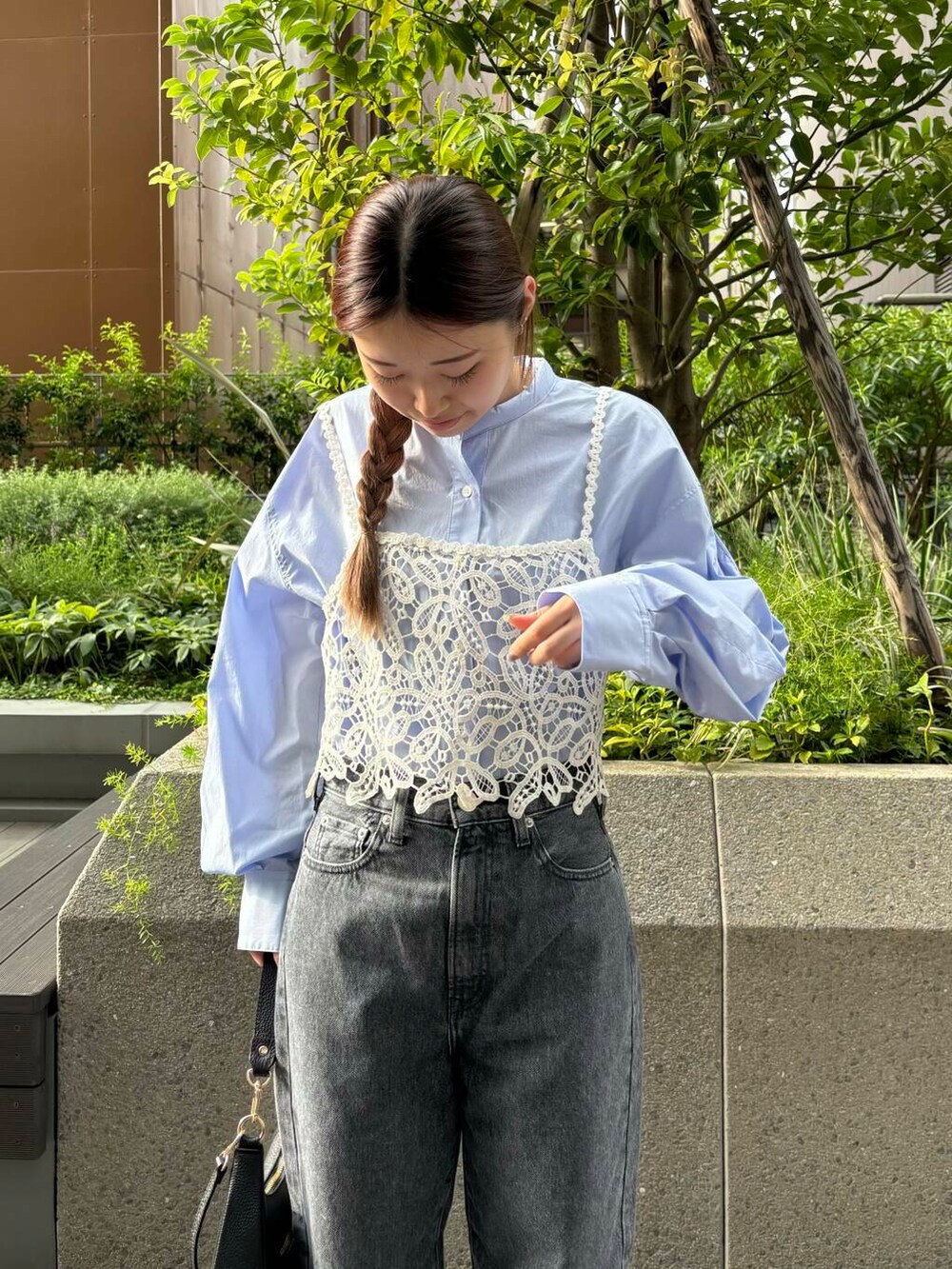 グレー系のデニムパンツ、ホワイト系のスニーカー、ブラック系のショルダーバッグを着用したレディースの夏コーディネートの4枚目の写真