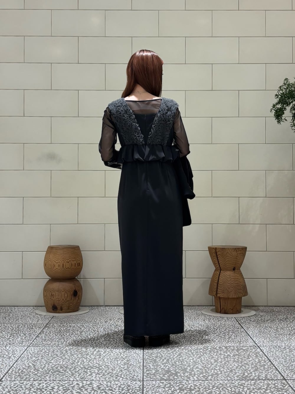 グレー系のドレス、ブラック系のテーラードジャケット、シルバー系のハンドバッグを着用したレディースの春コーディネートの3枚目の写真