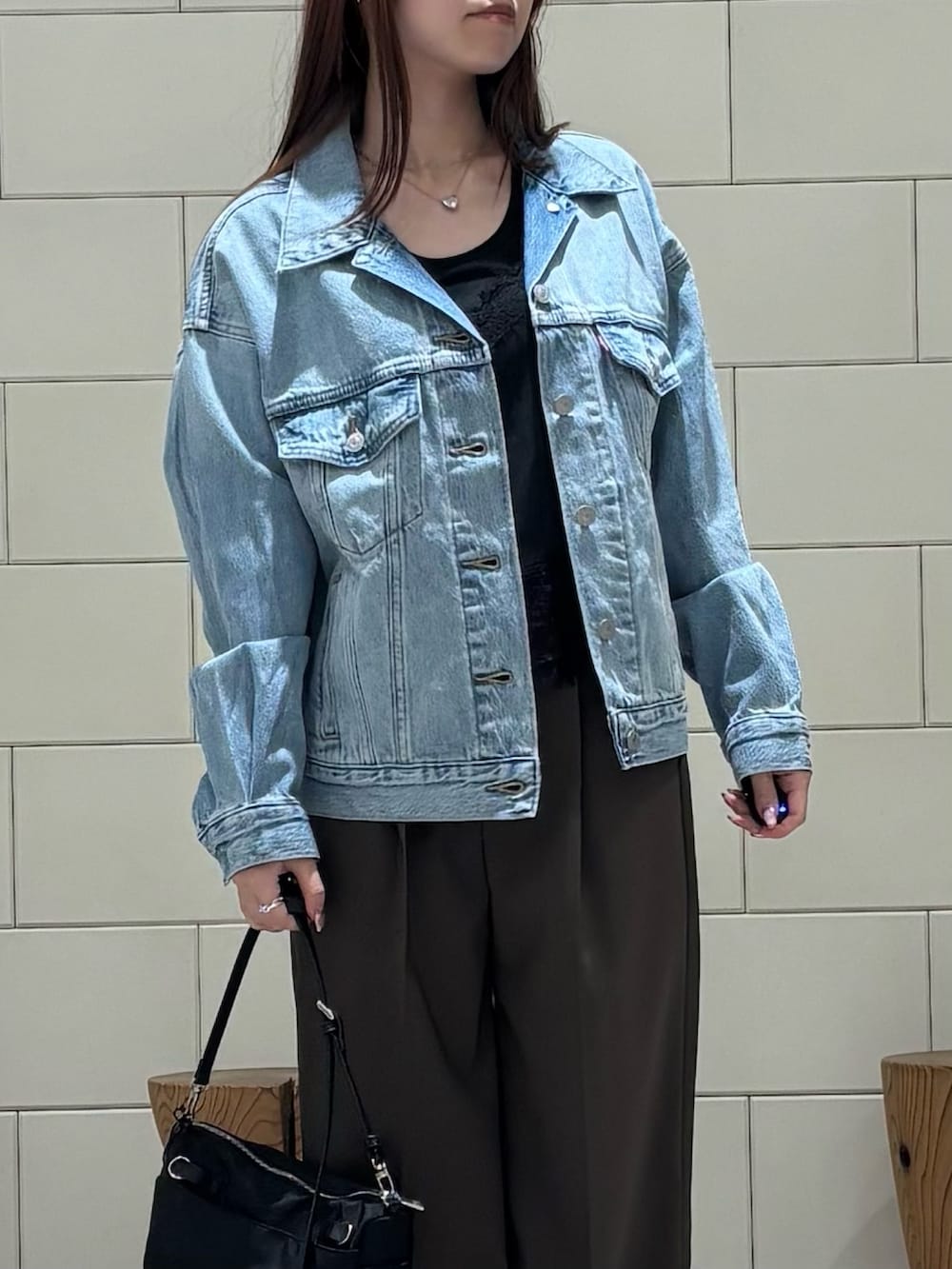 グレー系のTシャツ/カットソー、ブラック系のキャミソール、ブルー系のデニムジャケットを着用したレディースの冬コーディネートの4枚目の写真