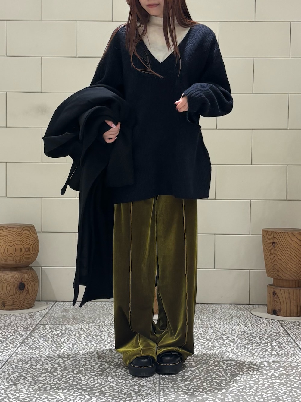 ホワイト系のニット/セーター、ブルー系のニット/セーター、ブラック系のチェスターコートを着用したレディースの冬コーディネートの5枚目の写真