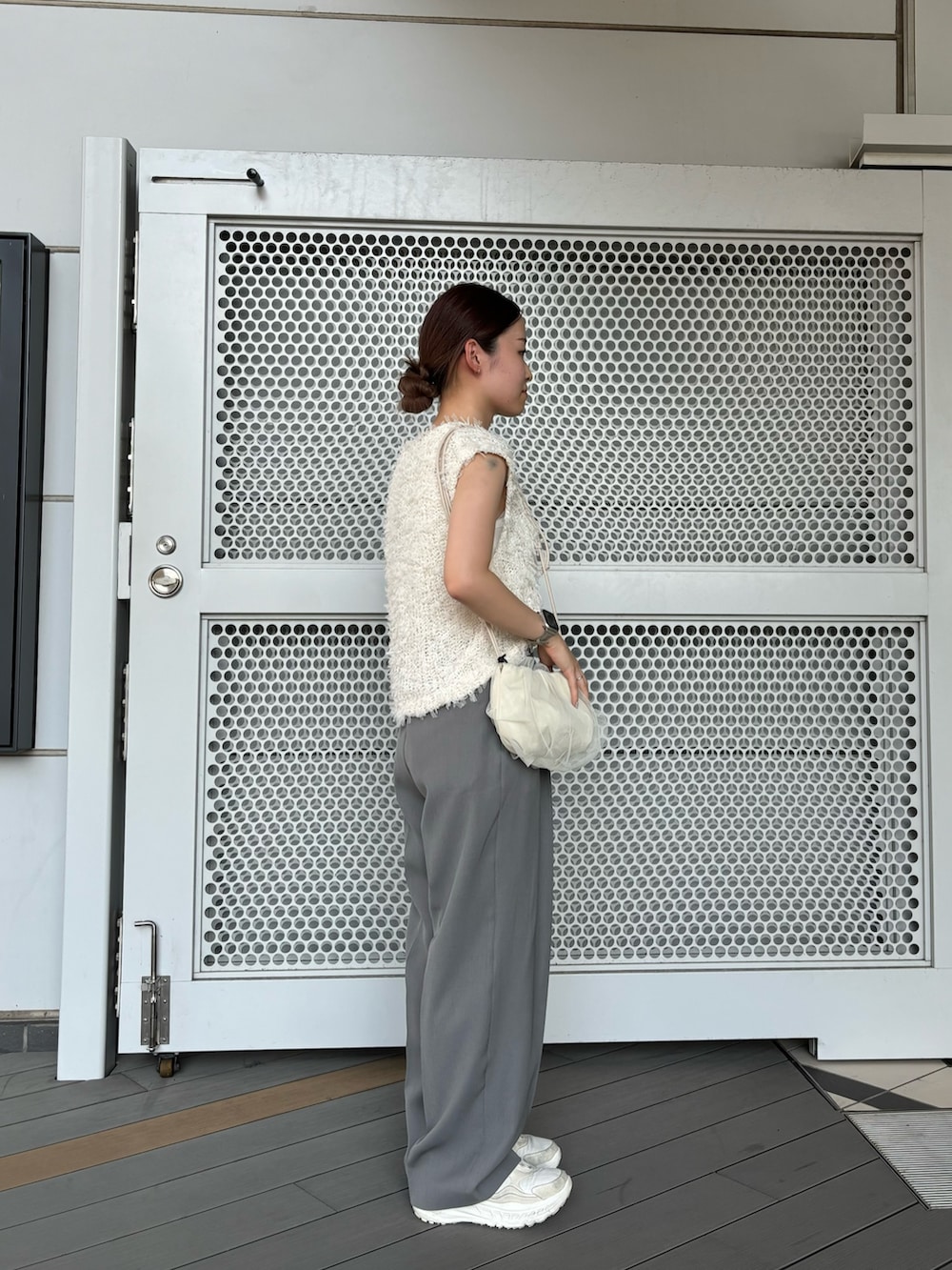グレー系のその他パンツ、ホワイト系のショルダーバッグ、ホワイト系のベストを着用したレディースの夏コーディネートの3枚目の写真