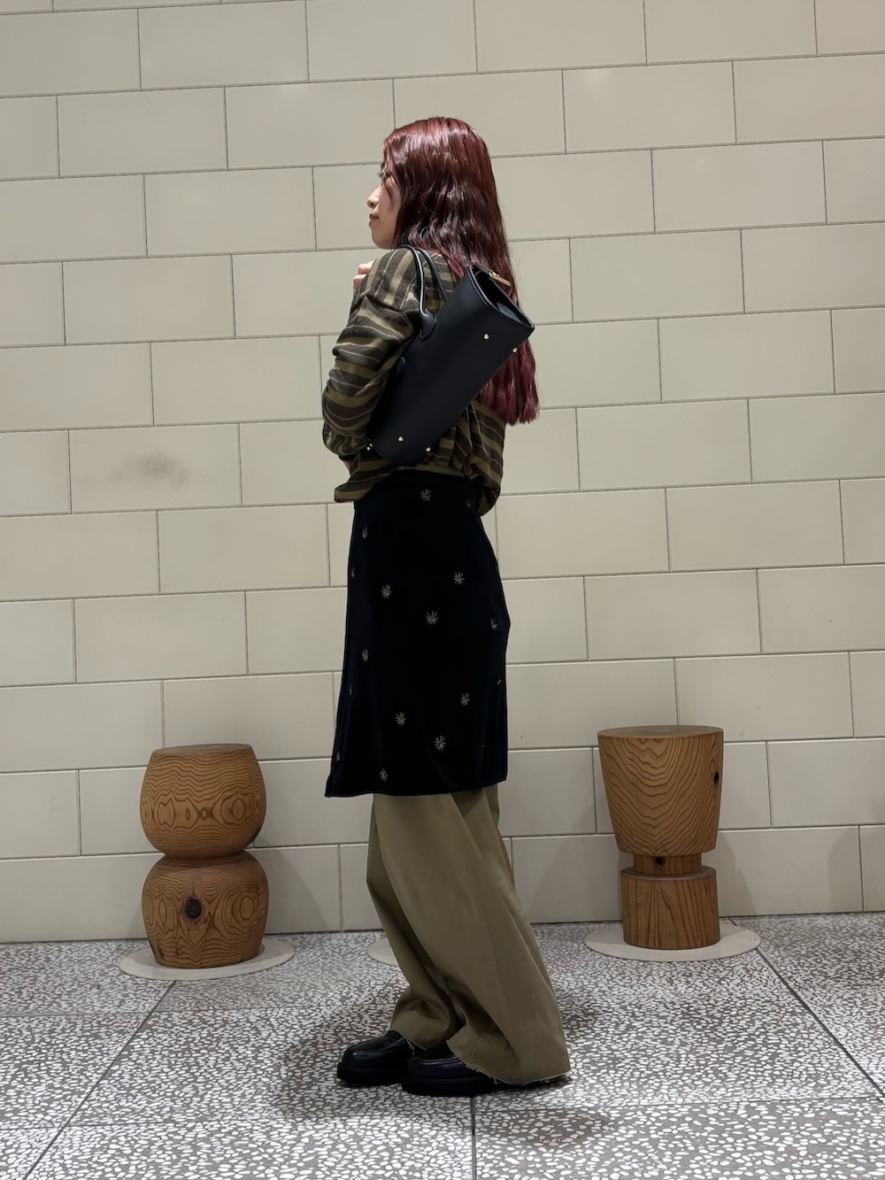 グリーン系のニット/セーター、ブラック系のスカート、ベージュ系のその他パンツを着用したレディースの秋コーディネートの3枚目の写真