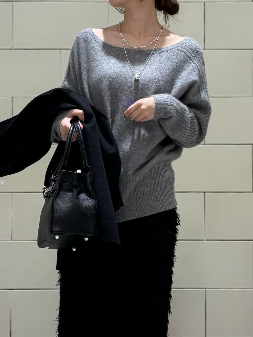 ブラック系のその他アウター、グレー系のニット/セーター、ブラック系のスカートを着用したレディースの秋コーディネートの4枚目の写真