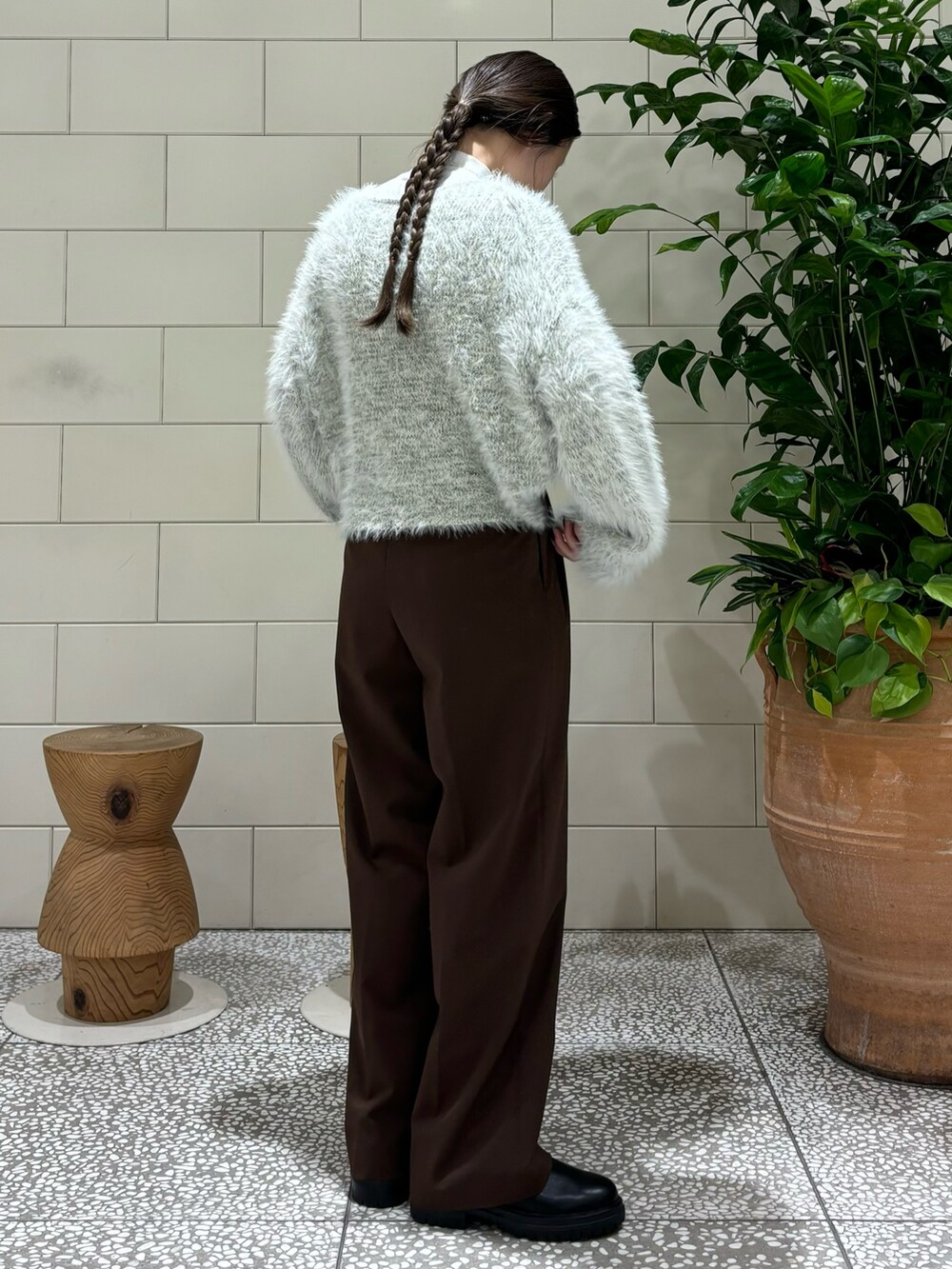 グレー系のニット/セーター、ブラック系のショルダーバッグ、ブラック系のブーツを着用したレディースの秋コーディネートの3枚目の写真