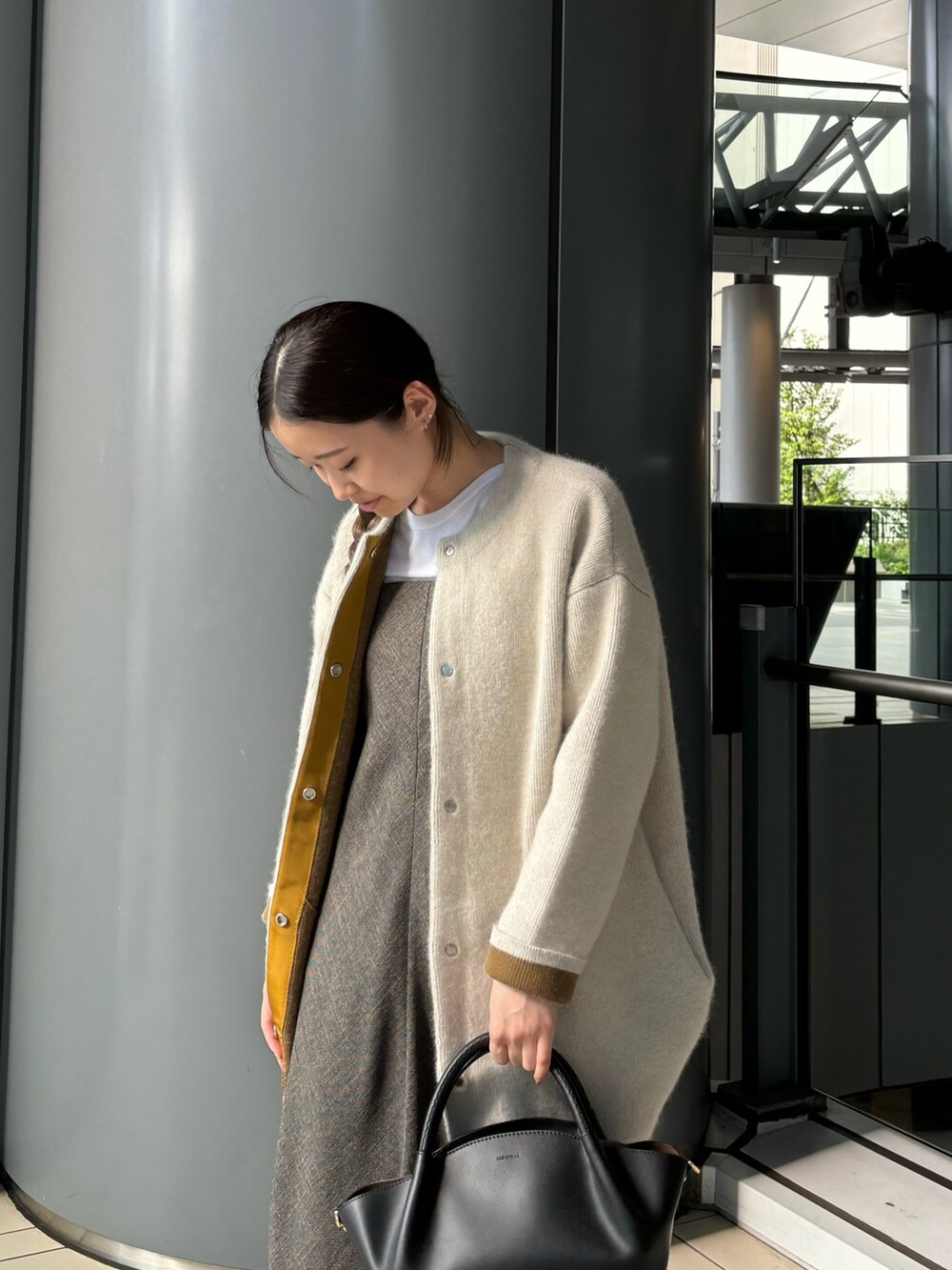 ブラウン系のワンピース、ブラック系のショルダーバッグ、ホワイト系のTシャツ/カットソーを着用したレディースの秋コーディネートの4枚目の写真