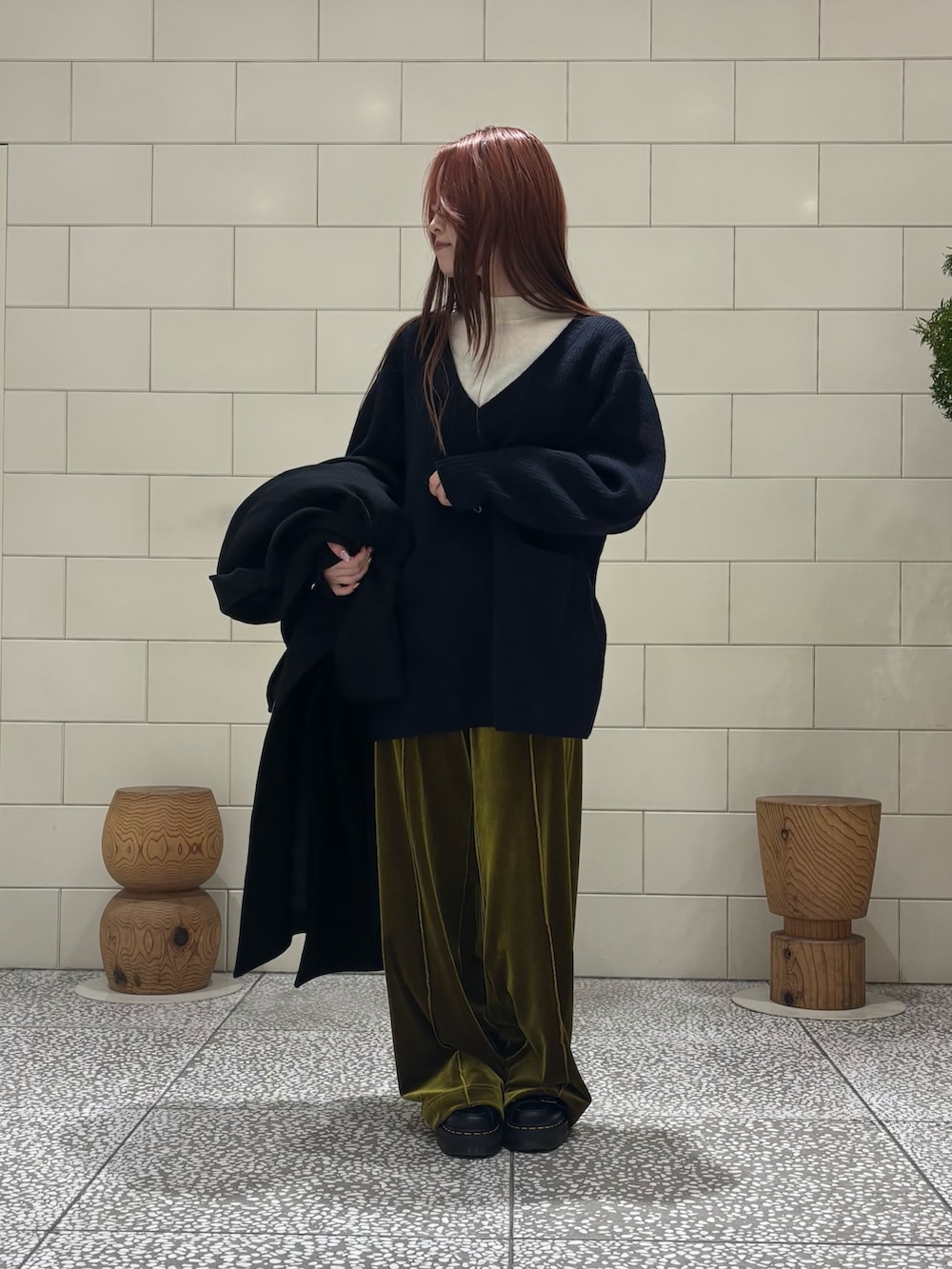 ホワイト系のニット/セーター、ブルー系のニット/セーター、ブラック系のチェスターコートを着用したレディースの冬コーディネートの3枚目の写真