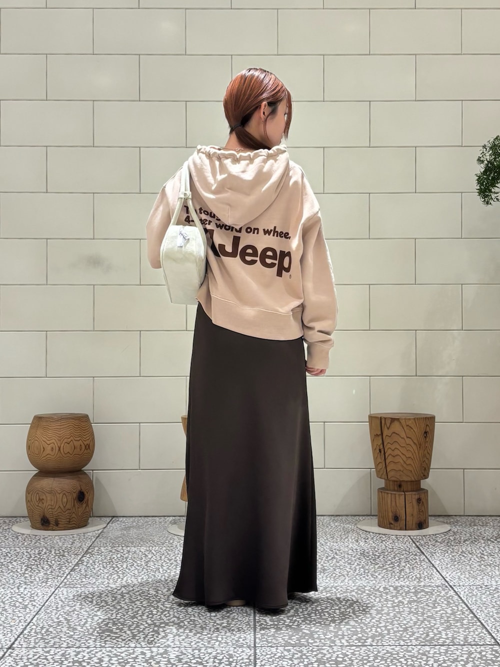 ホワイト系のスニーカー、ブラウン系のスカートを着用したレディースの冬コーディネートの3枚目の写真