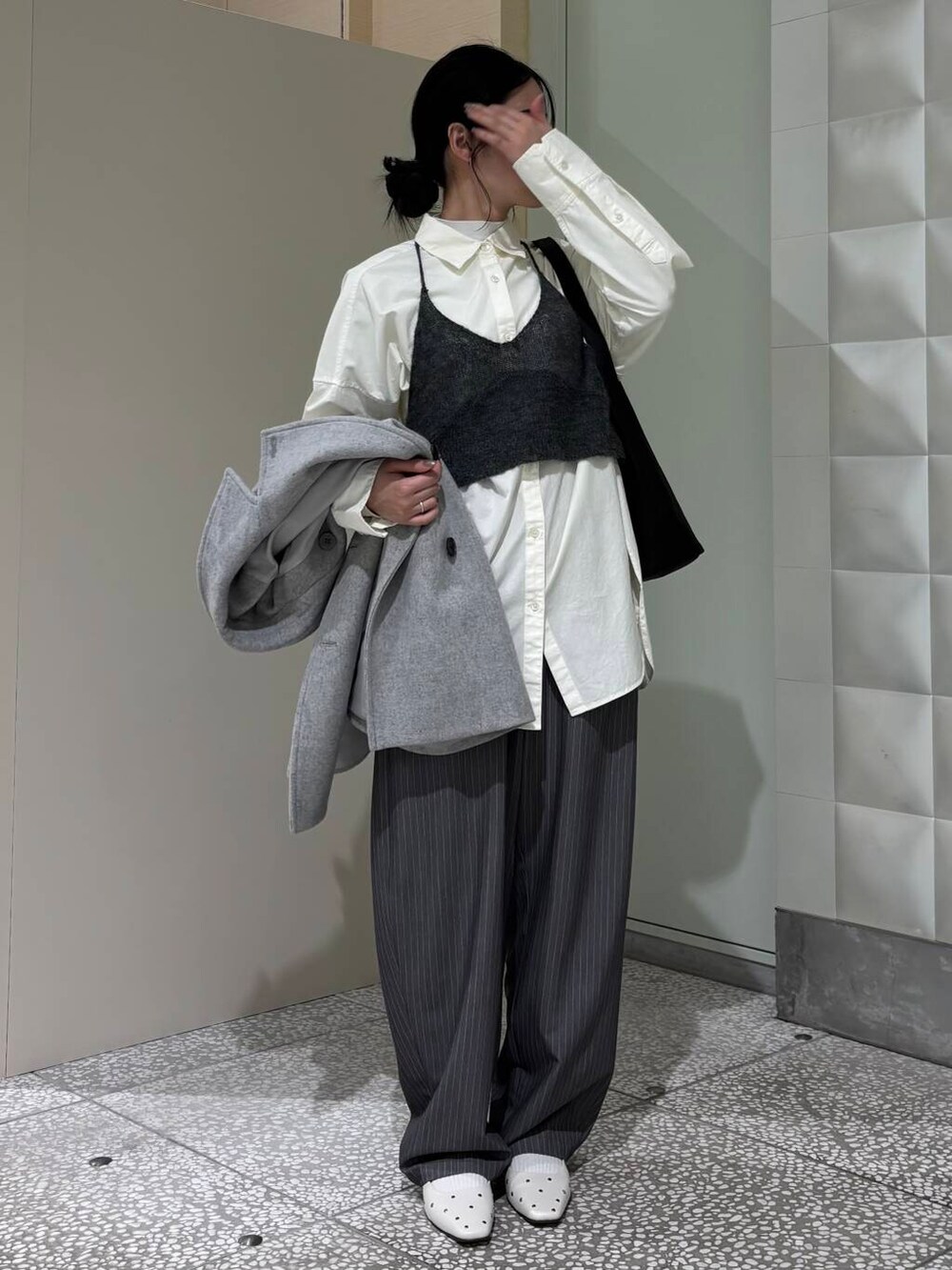 グレー系のピーコート、ホワイト系のシャツ/ブラウス、ホワイト系のパンプスを着用したレディースの冬コーディネートの2枚目の写真