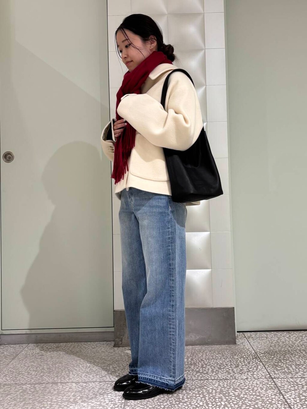 ブラック系のニット/セーター、ブルー系のデニムパンツ、ホワイト系のその他アウターを着用したレディースの秋コーディネートの2枚目の写真