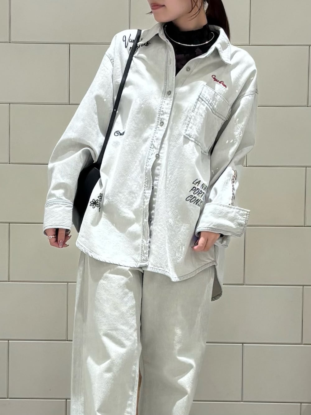 ブラック系のTシャツ/カットソー、グレー系のシャツ/ブラウス、グレー系のデニムパンツを着用したレディースの冬コーディネートの4枚目の写真