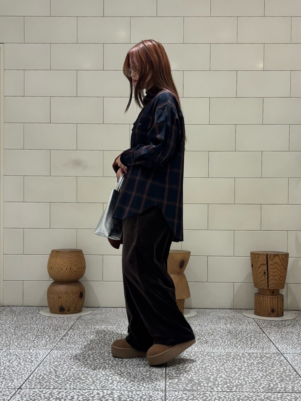 ブラック系のTシャツ/カットソー、ブラウン系のステンカラーコート、シルバー系のトートバッグを着用したレディースの冬コーディネートの3枚目の写真