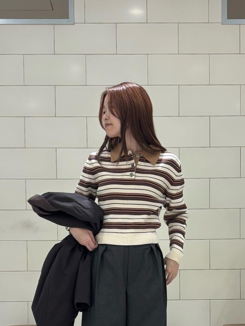 ブラウン系のダウンジャケット/コート、グレー系のその他パンツ、ベージュ系のスニーカーを着用したレディースの冬コーディネートの4枚目の写真