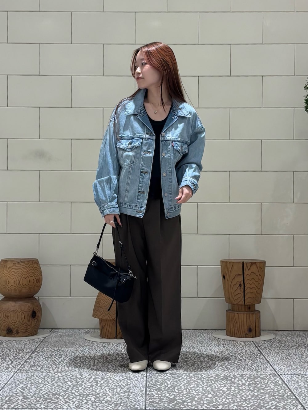 グレー系のTシャツ/カットソー、ブラック系のキャミソール、ブルー系のデニムジャケットを着用したレディースの冬コーディネートの2枚目の写真