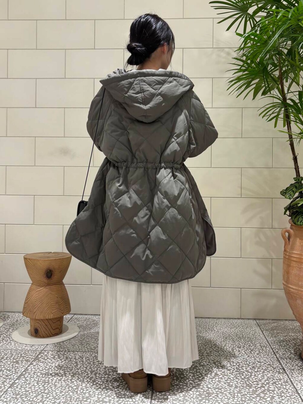 ブラウン系のニット/セーター、ホワイト系のスカート、グレー系のダウンジャケット/コートを着用したレディースの冬コーディネートの4枚目の写真